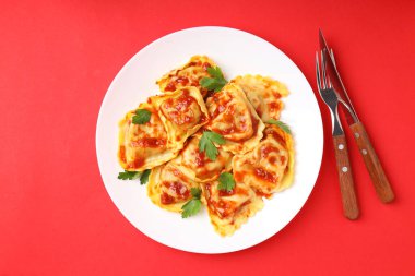 Kırmızı arka planda ravioli olan lezzetli yemek kavramı.