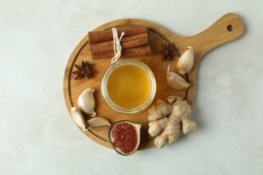 Beyaz dokulu arka planda bal ve sarımsak içeren soğuk algınlığı tedavisi kavramı