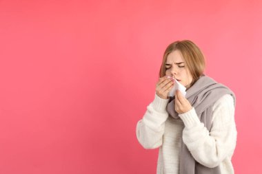 Pembe arka plandaki hasta genç kadın, mevsimsel soğuk kavramı