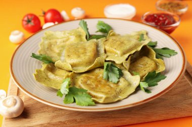 Turuncu arka planda ravioli olan lezzetli yemek kavramı.