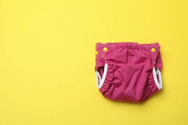 Sarı arka planda yeniden kullanılabilir bebek bezleri, kapatın.