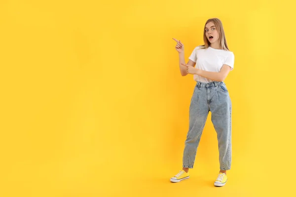 Sarı Arka Planda Kot Pantolonlu Çekici Bir Kız — Stok fotoğraf