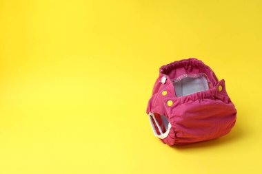 Sarı arka planda yeniden kullanılabilir bebek bezleri, kapatın.