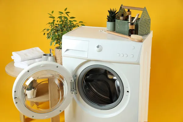 Conceito Trabalho Doméstico Com Máquina Lavar Roupa Fundo Amarelo — Fotografia de Stock