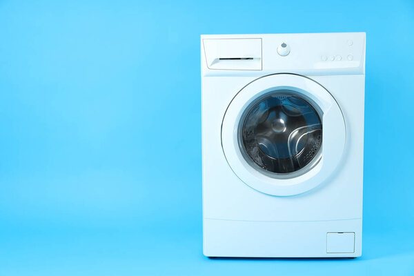 Modern white washing machine on blue background