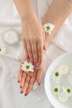 Beyaz havlu arka planında kozmetik ürünlerle el bakımı kavramı