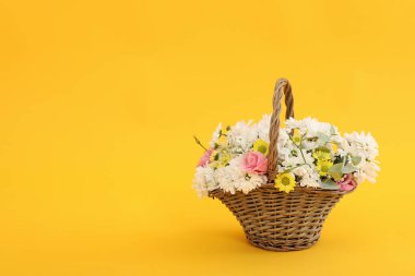 Sarı arka planda güzel çiçekli sepet.