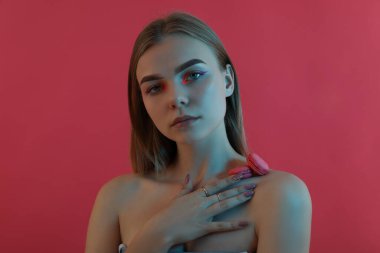 Pembe arka planda makyajlı güzel bir kız.