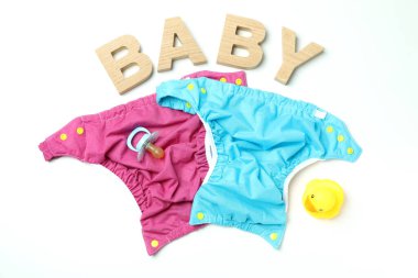 Beyaz arka planda yeniden kullanılabilir bebek bezi olan bebek kıyafetleri kavramı