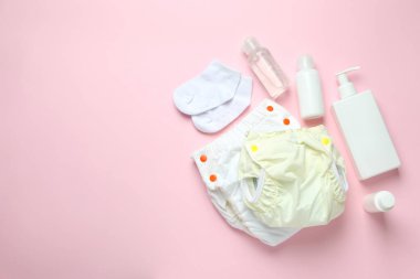Pembe arka planda yeniden kullanılabilir bebek bezi olan bebek kıyafetleri kavramı