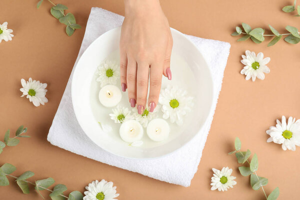 Concept of hand care on beige background with flowers