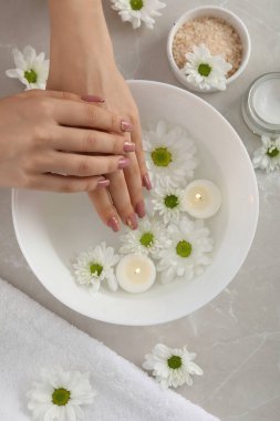 Gri dokulu arka planda kozmetik içeren el bakımı kavramı