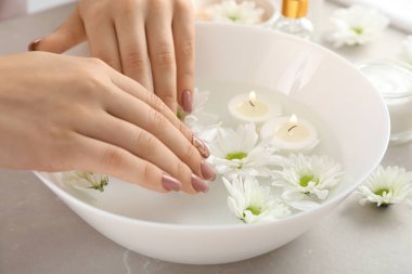 Gri dokulu arka planda kozmetik içeren el bakımı kavramı