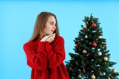 Çekici kadın ve mavi arka planda Noel ağacı