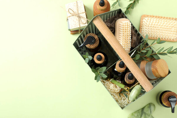 Concept of gift with basket of cosmetics on green background