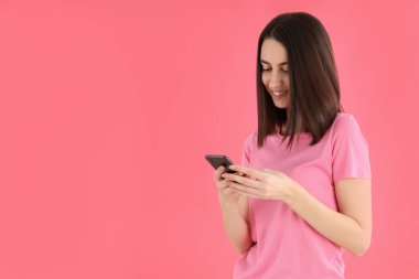 Pembe arka planda telefonu olan kadın, mesaj için boşluk