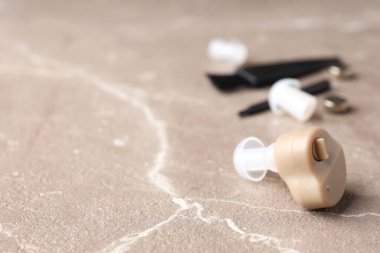 Bej dokulu arka planda işitme cihazı ile sağlık hizmeti kavramı