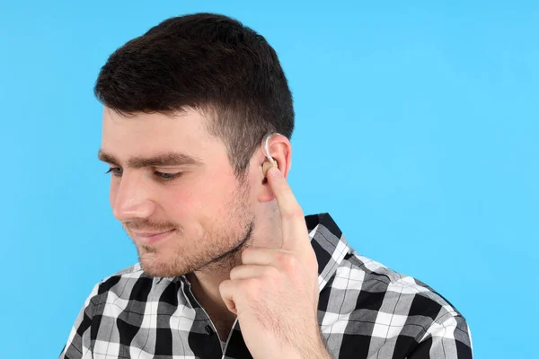 Junger Mann Mit Hörgerät Auf Blauem Hintergrund — Stockfoto