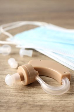 Ahşap arka planda işitme cihazı ile sağlık hizmeti kavramı