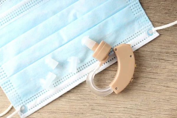 Ahşap arka planda işitme cihazı ile sağlık hizmeti kavramı