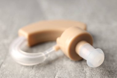 Gri dokulu arka planda işitme cihazı, kapat