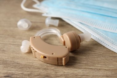 Ahşap arka planda işitme cihazı ile sağlık hizmeti kavramı