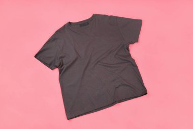 Pembe arka planda baskı için yeri olan koyu renk tişört.