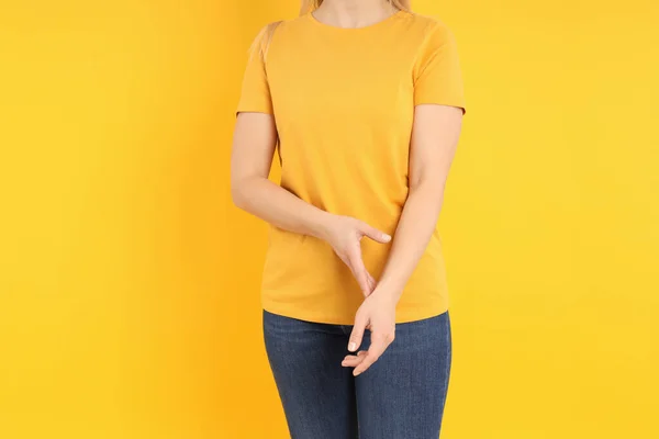 Sarı Arka Planda Boş Turuncu Tişörtlü Kadın — Stok fotoğraf