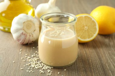 Tahini soslu lezzetli yemek kavramı hafif ahşap arka planda