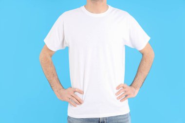 Mavi arka planda beyaz tişörtlü adam.