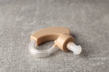 Gri dokulu arka planda işitme cihazı, kapat