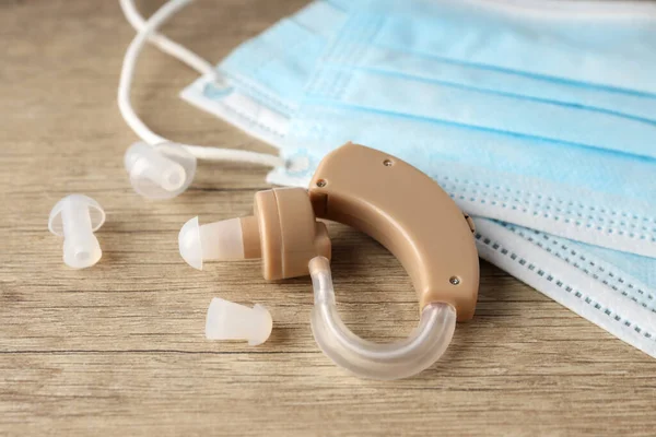 Ahşap arka planda işitme cihazı ile sağlık hizmeti kavramı