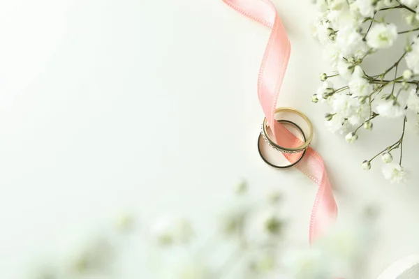 Concept of wedding accessories with wedding rings on white background