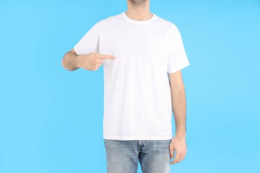 Mavi arka planda beyaz tişörtlü adam.