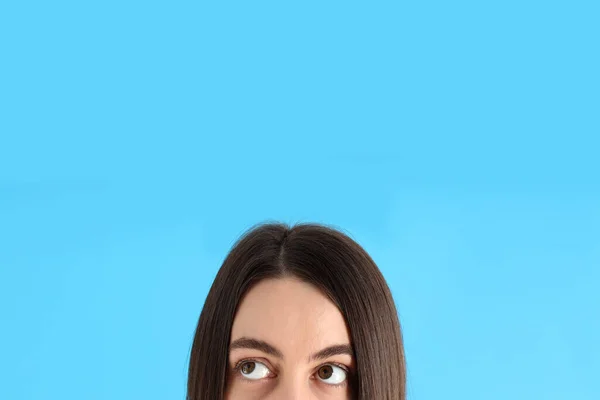 一个蓝色背景的年轻女孩的半张脸 — 图库照片