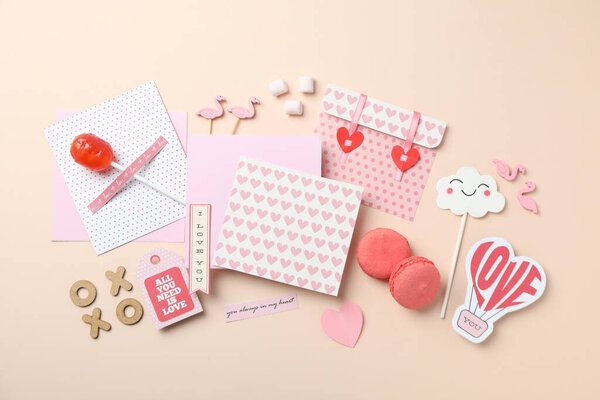 Аксессуары ко Дню Святого Валентина на бежевом фоне, вид сверху