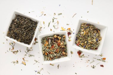 Beyaz zemin üzerinde farklı çay türleri olan çay pişirme kavramı