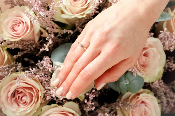 女性手とともに結婚指輪上のウェディング花束の背景 — ストック写真