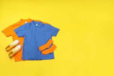 Sarı arka planda boş tişörtler, spor ayakkabılar ve çoraplar