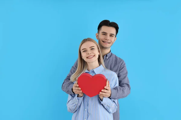 Sevimli Bir Çift Mavi Arka Planda Kalbi Tutuyor — Stok fotoğraf