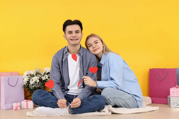 Bonito Feliz Casal Sentado Contra Fundo Amarelo — Fotografia de Stock