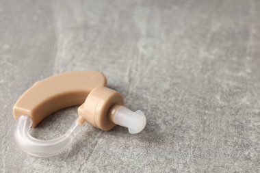 Gri dokulu arka planda işitme cihazı, kapat