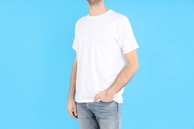 Mavi arka planda beyaz tişörtlü adam.
