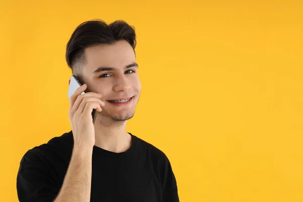 Anak Muda Berbicara Telepon Pada Latar Belakang Kuning — Stok Foto