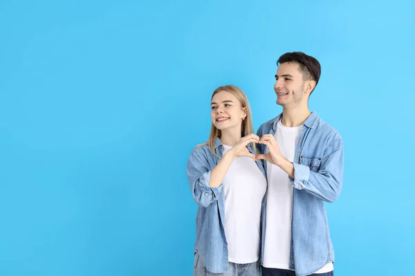 Linda Pareja Mostrando Signo Amor Sobre Fondo Azul —  Fotos de Stock