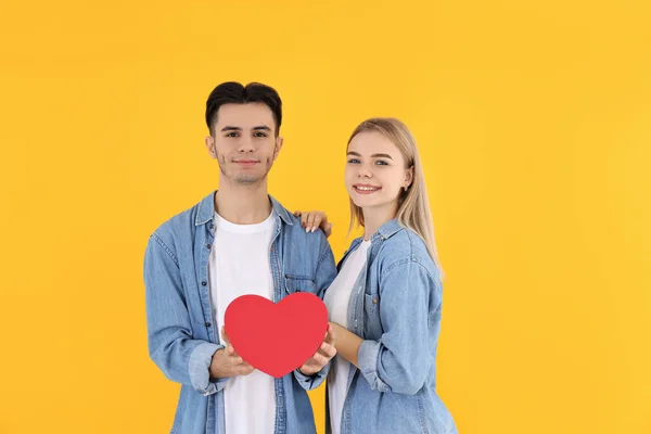 Sarı Arka Planda Kalbi Olan Sevimli Bir Çift — Stok fotoğraf