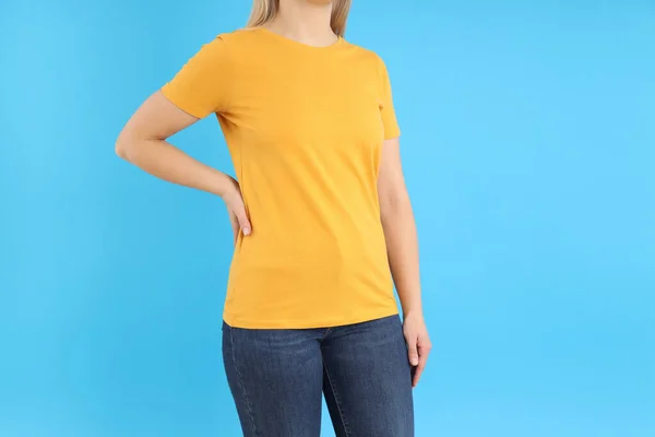 Wanita Dengan Kaos Oranye Kosong Dengan Latar Belakang Biru — Stok Foto