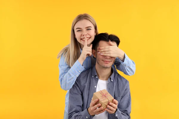 Nettes Paar Mit Geschenkbox Auf Gelbem Hintergrund — Stockfoto