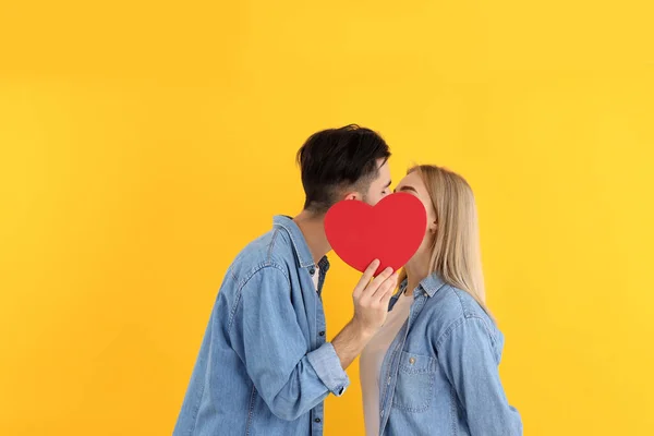 Linda Pareja Con Corazón Sobre Fondo Amarillo —  Fotos de Stock