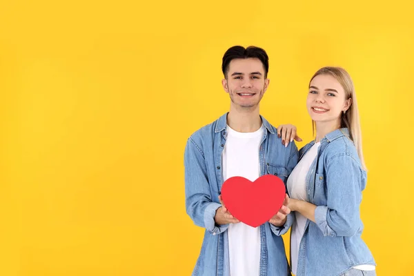 Linda Pareja Con Corazón Sobre Fondo Amarillo —  Fotos de Stock